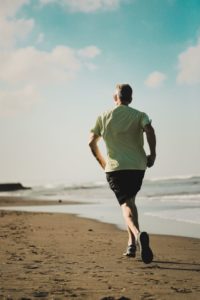 Man running along the shore line